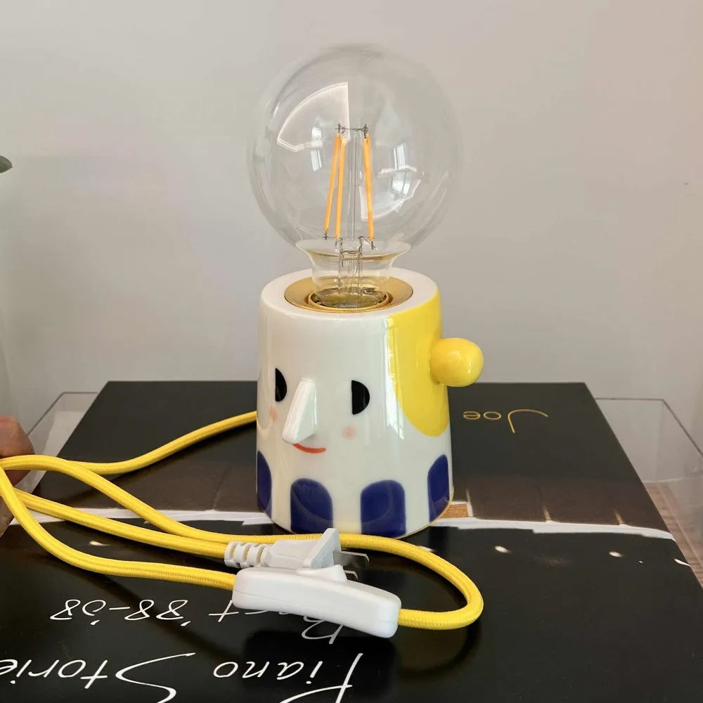 Handmade ceramic bedside lamp with ball headlight design on wooden nightstand