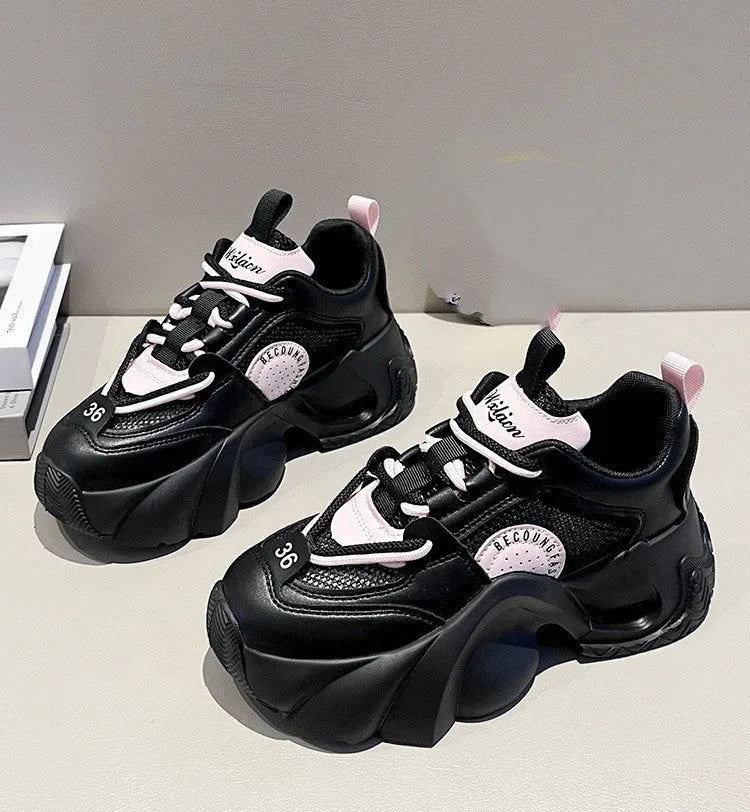 Women's pink sneakers with cross shoulder straps, thick sole, and mesh lining on a white background.