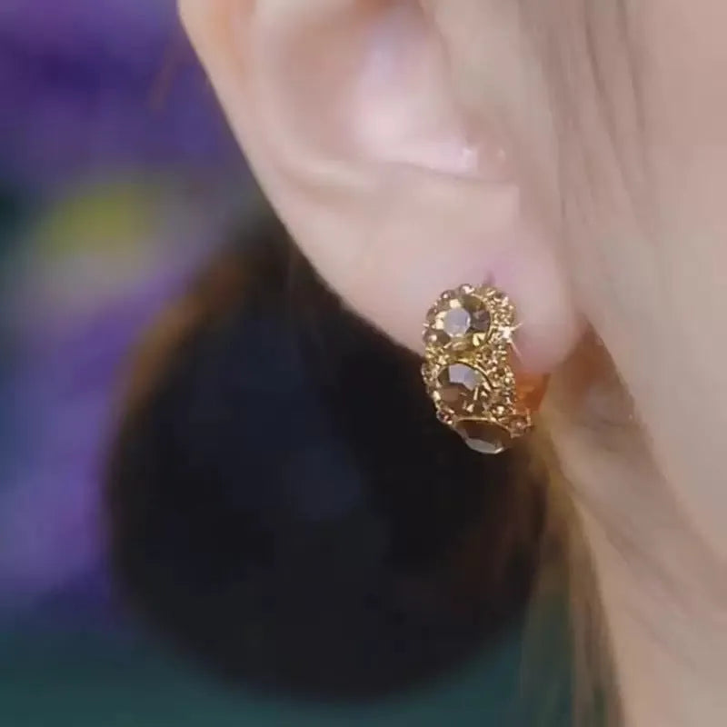 Gold metal hoop earrings with diamond surface treatment and brown zircon stones