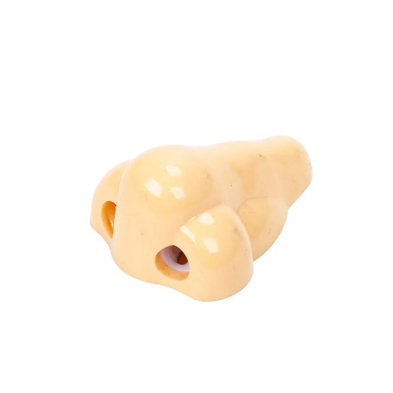 Flesh-coloured plastic geometry-shaped pencil sharpener with a large nostril.
