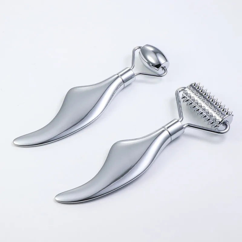 Stainless steel facial massage roller and heart-shaped gua sha plate set on a white background.