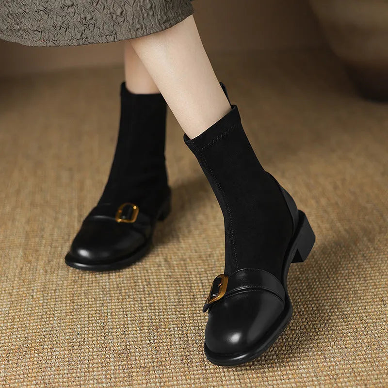 Women's black low heel ankle boots with martin-style buckle stitching and white lace-up front.