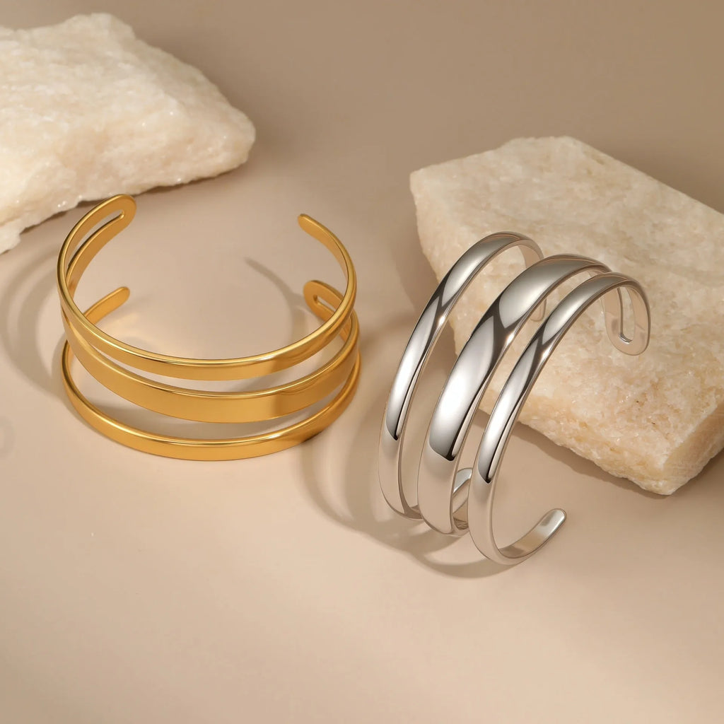 A geometric line design bracelet for women on wrist, shown in stainless steel with a simple opening clasp.