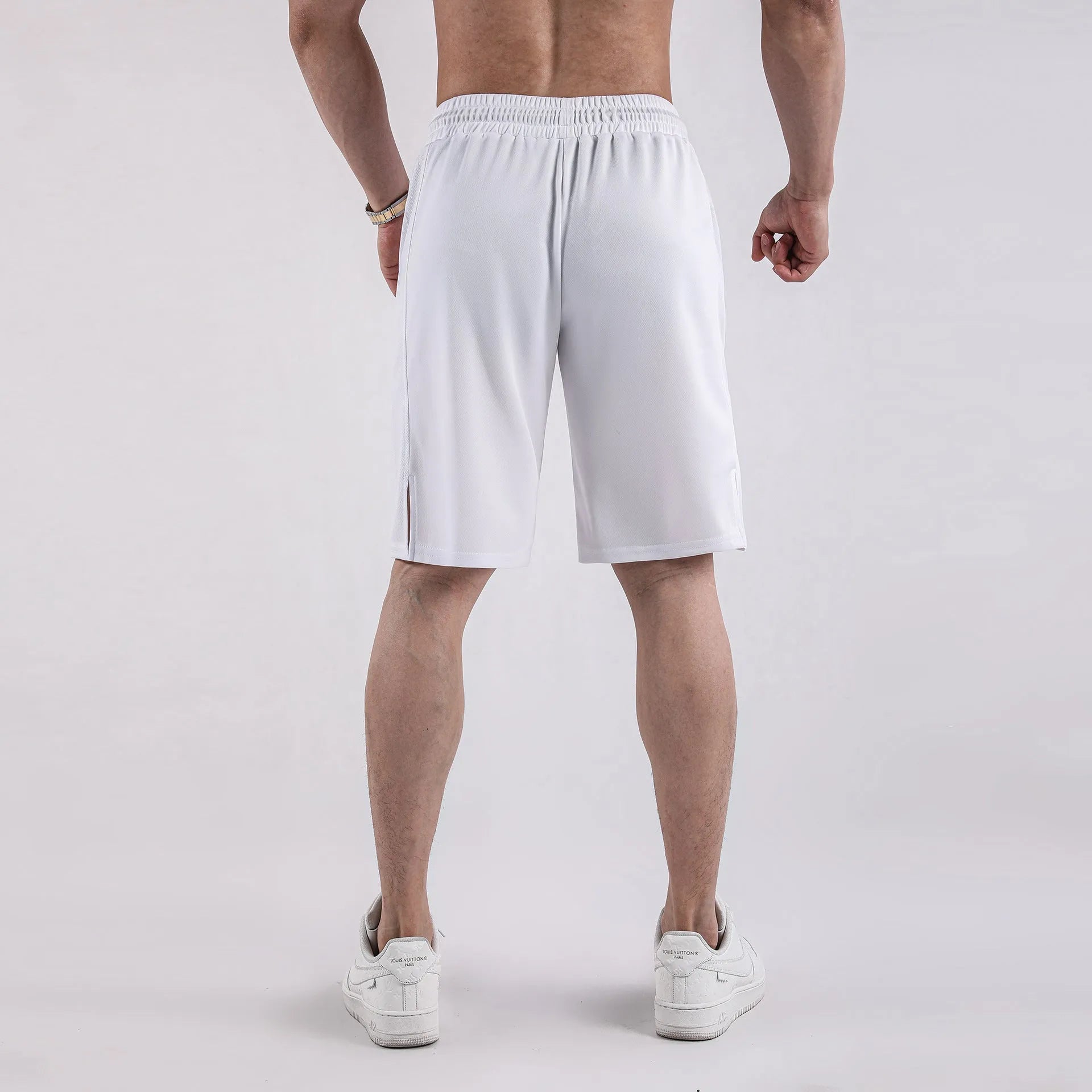Man wearing loose black capri-length fitness shorts with an elasticated waistband.