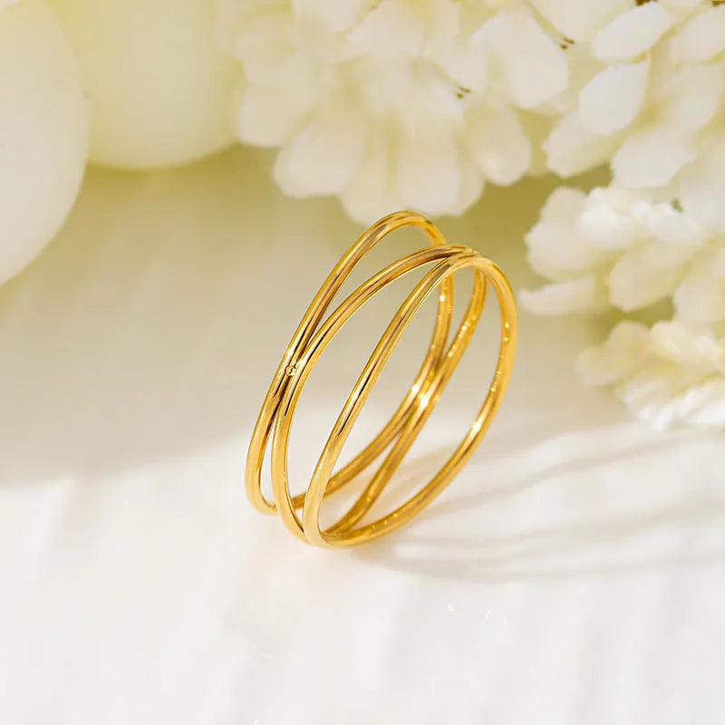 Geometric gold-coloured titanium steel ring with three-layer coil design shown at various angles