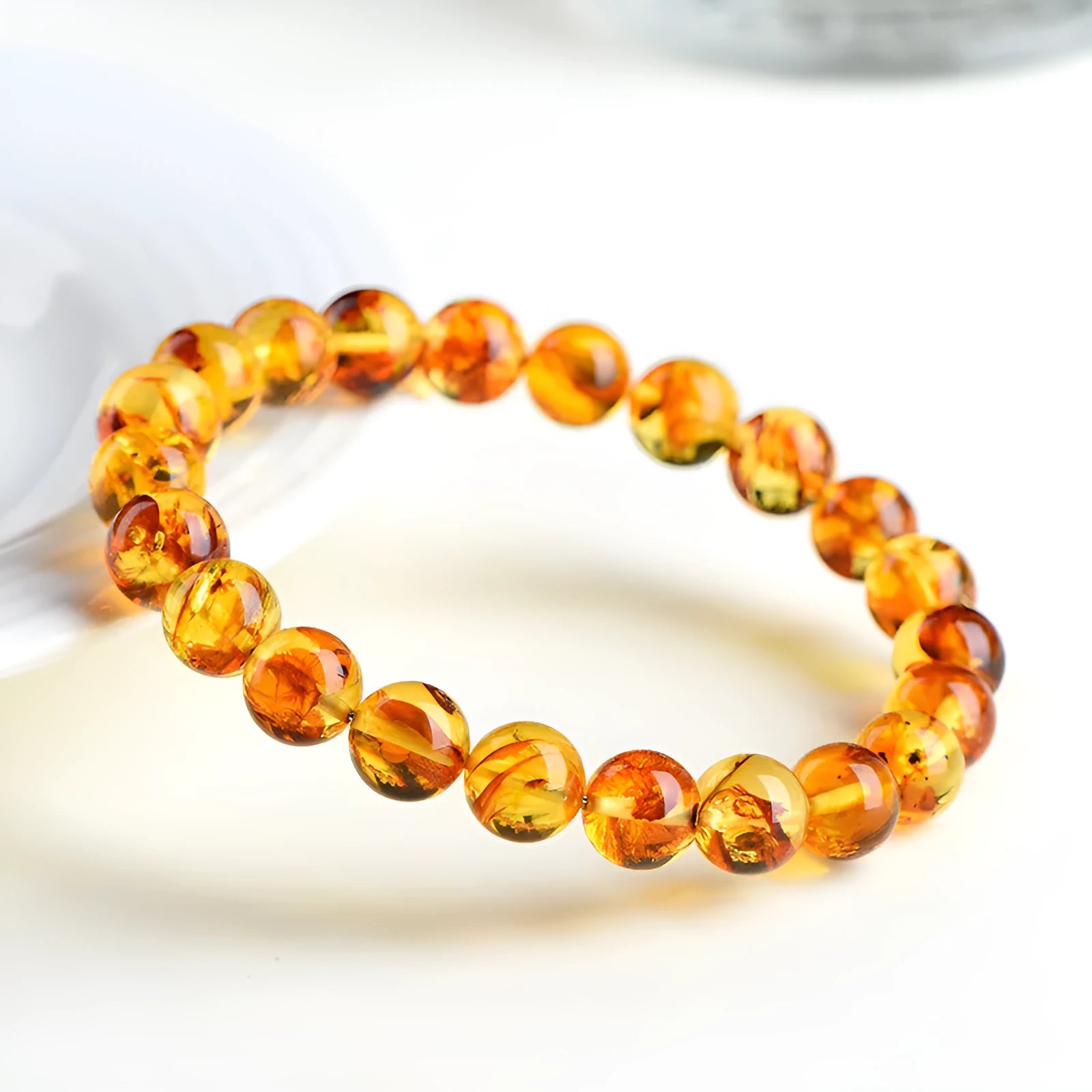 Natural yellow piebald amber bracelet with geometric beads on wrist.