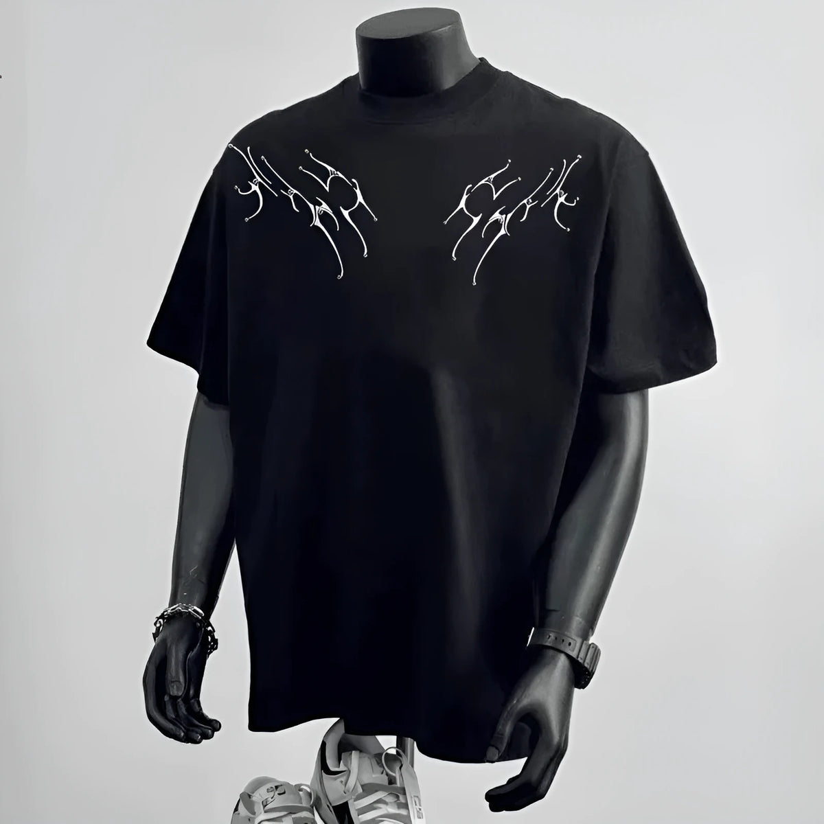 Man wearing a loose-fit black cotton T-shirt with a white printed letter design on the front.