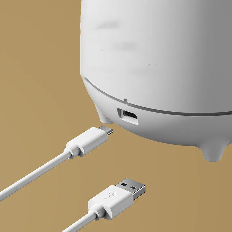 Volcano-shaped white humidifier with USB cable and mist rising from single outlet