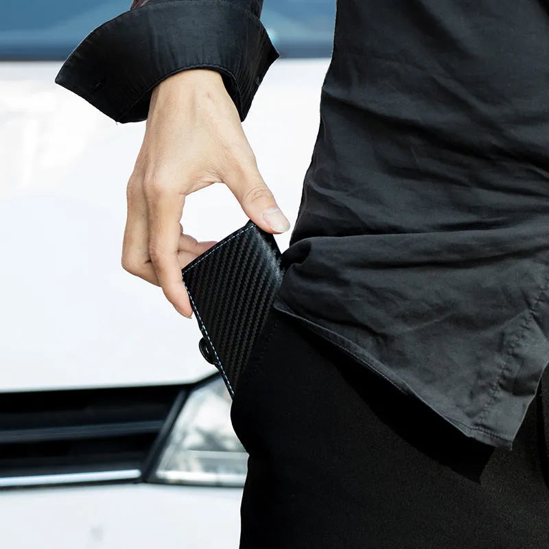 Zipper RFID card holder in carbon fibre with plaid finish, black leather with blue stitching, showing card slots and secret compartment