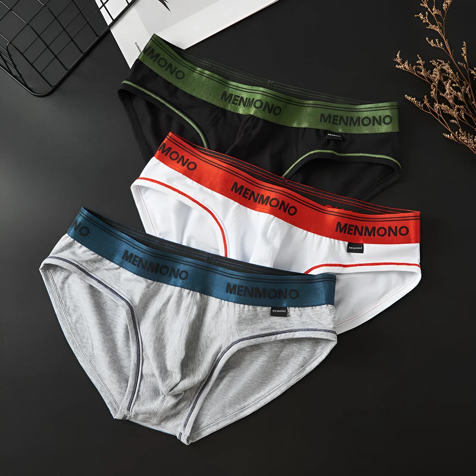 Men's low-waist cotton briefs showing colour options including white/blue, black/red, and grey/green