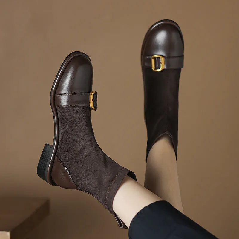 Women's black low heel ankle boots with martin-style buckle stitching and white lace-up front.