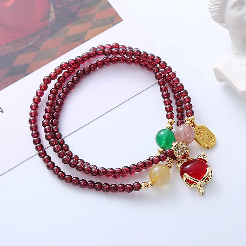 Purplish red garnet fox bracelet on an adjustable rope for women.