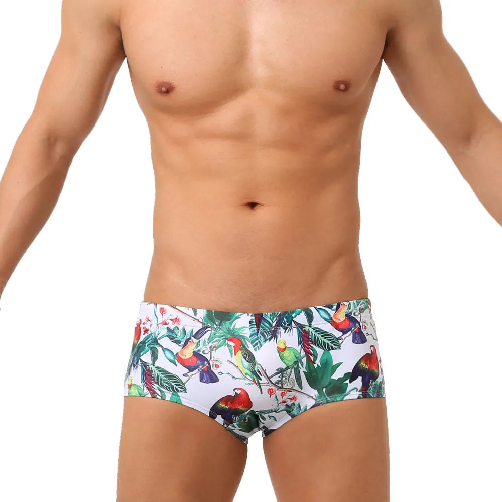 Men's navy blue swimming trunks with colourful flower and bird print pattern.