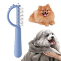 Blue dinosaur-shaped self-cleaning cat brush with double-sided stainless steel pins.