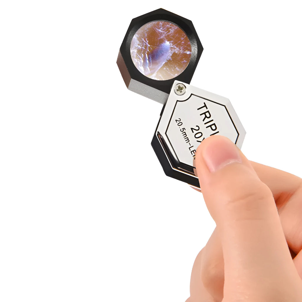 Handheld metal magnifying glass with optical glass lens for jewellery and coin identification.