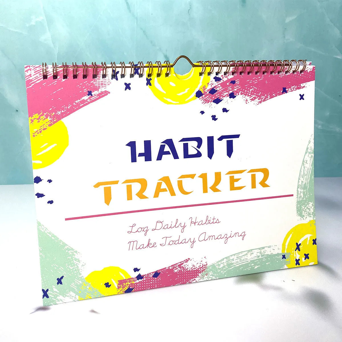 12-page habit tracking journal in pink and white, showing its 21cm by 28cm size.