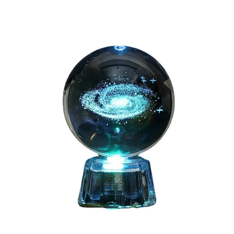 6cm transparent crystal ball ornament with illuminated inner carving of celestial designs on a table