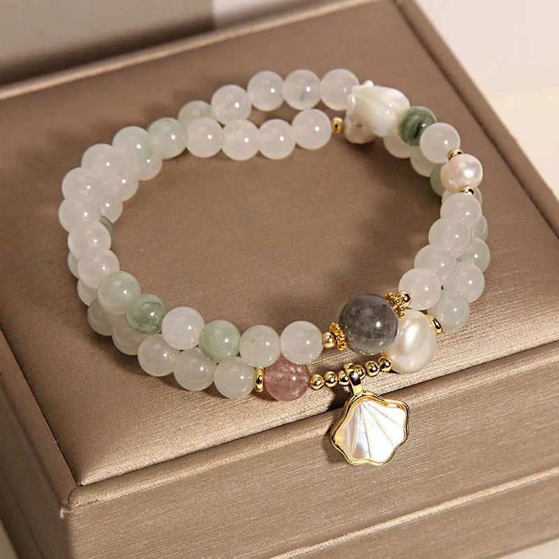 Women's crystal bracelet with a large green ginkgo leaf pendant, gold metalwork, and sparkling rhinestones.