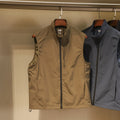 Men's straight-cut nylon vest in army green with side seam pockets, laid flat.