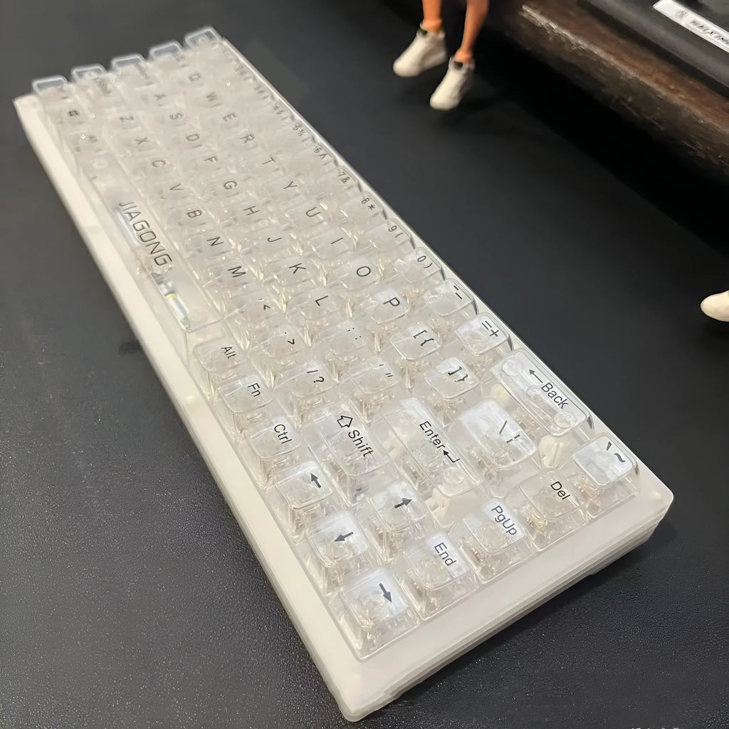 Transparent plastic keyboard key caps arranged as complete 132-key set for mechanical keyboard replacement