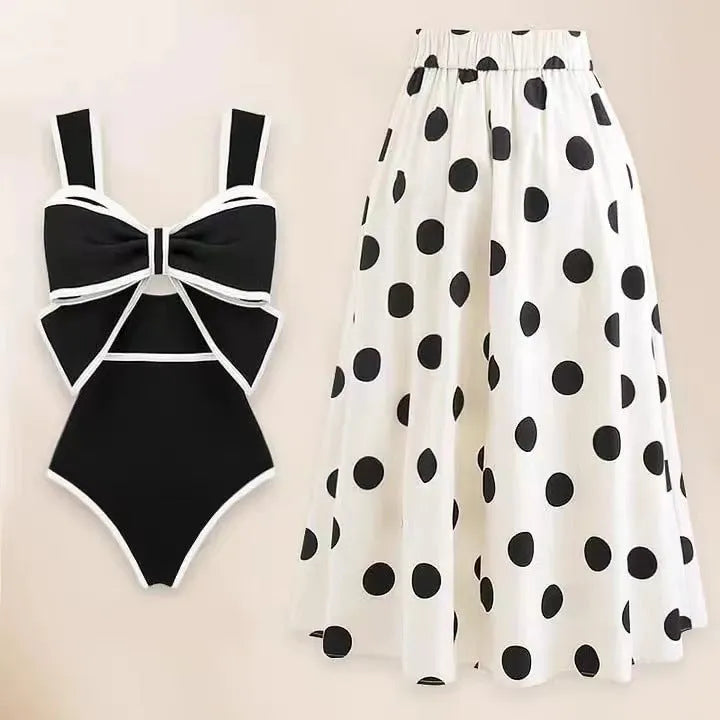 Women's black one-piece swimsuit with circular skirt and bow detail for beach and pool swimming