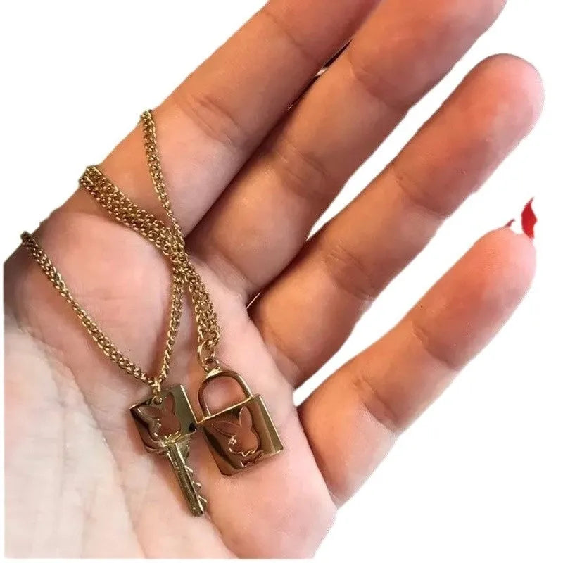 Shiny alloy key lock pendant necklace with geometric shape and electroplated finish on white background