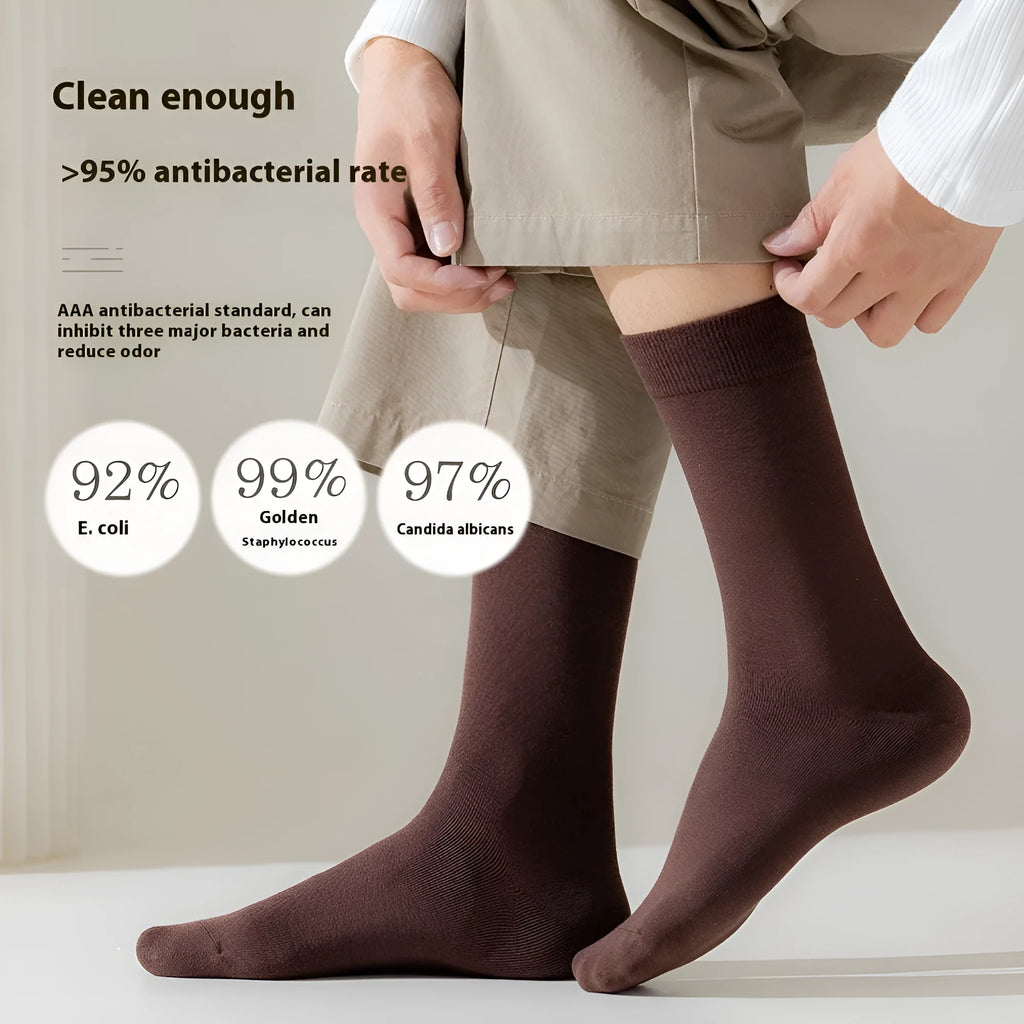 Men's solid colour mid-calf socks in combed cotton, shown in a range of neutral shades including beige, black, and dark blue.