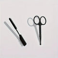 Black dual-ended pet grooming brush with soft brush and comb on a white background.