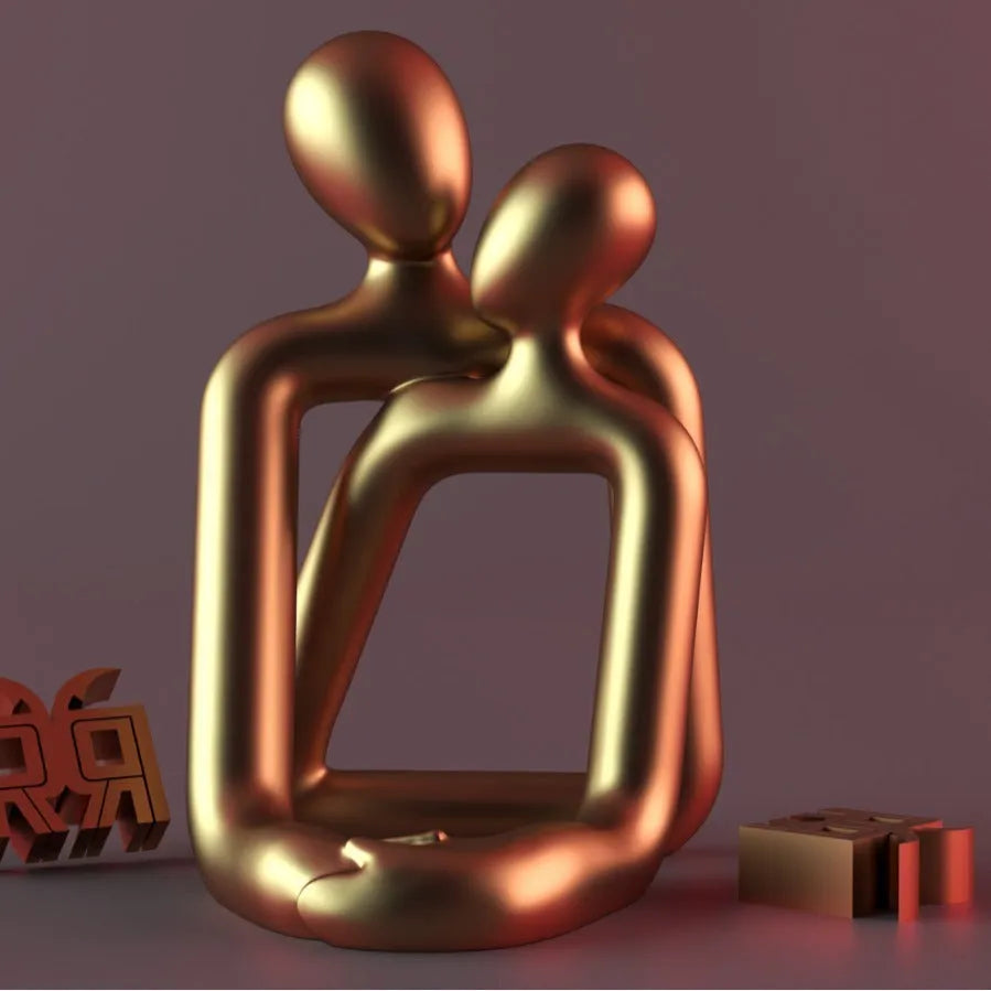 Modern minimalist resin statue of a couple in milky white or gold colour on a wooden surface.