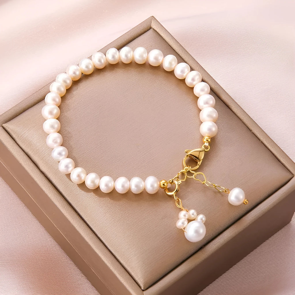 Women's white freshwater pearl cat's paw bracelet with electroplating finish on a neutral background