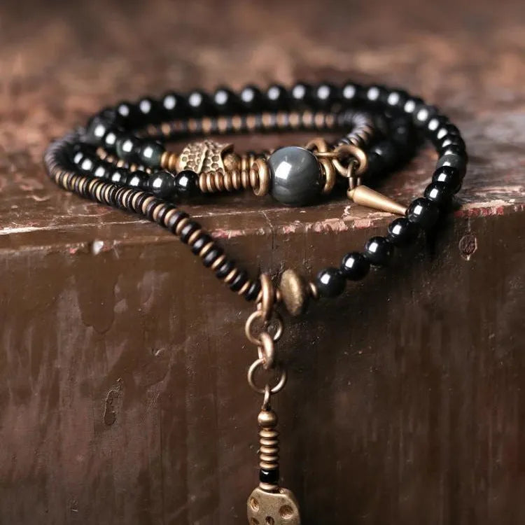 Black multi-layered beaded bracelet with geometric styling on wrist