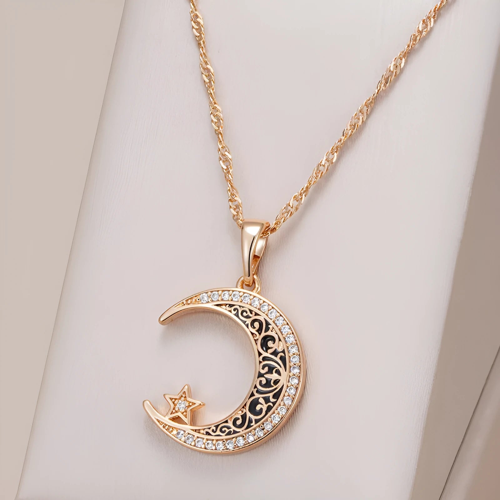 Rose gold star and moon zircon pendant necklace with enamel detail on a water wave chain.