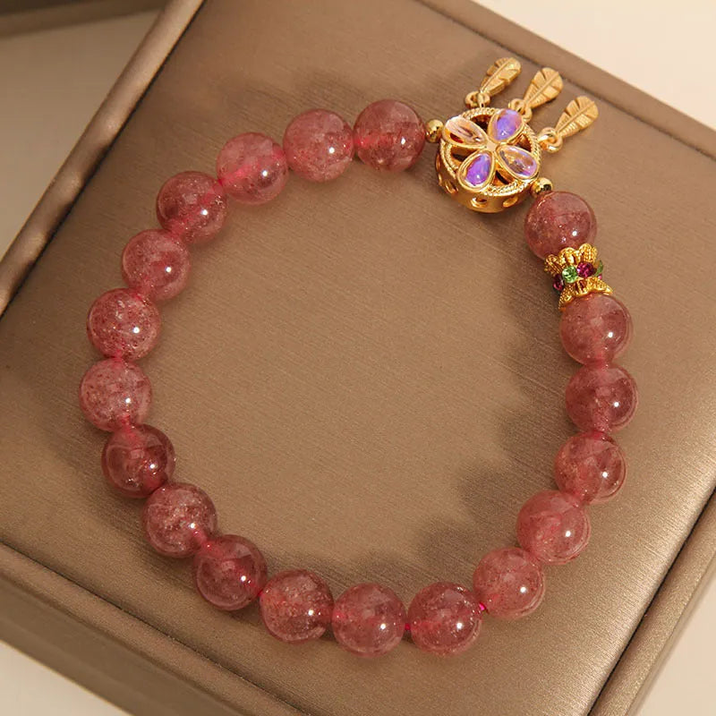 Women's strawberry quartz crystal bracelet with a four leaf dream catcher ball pendant.