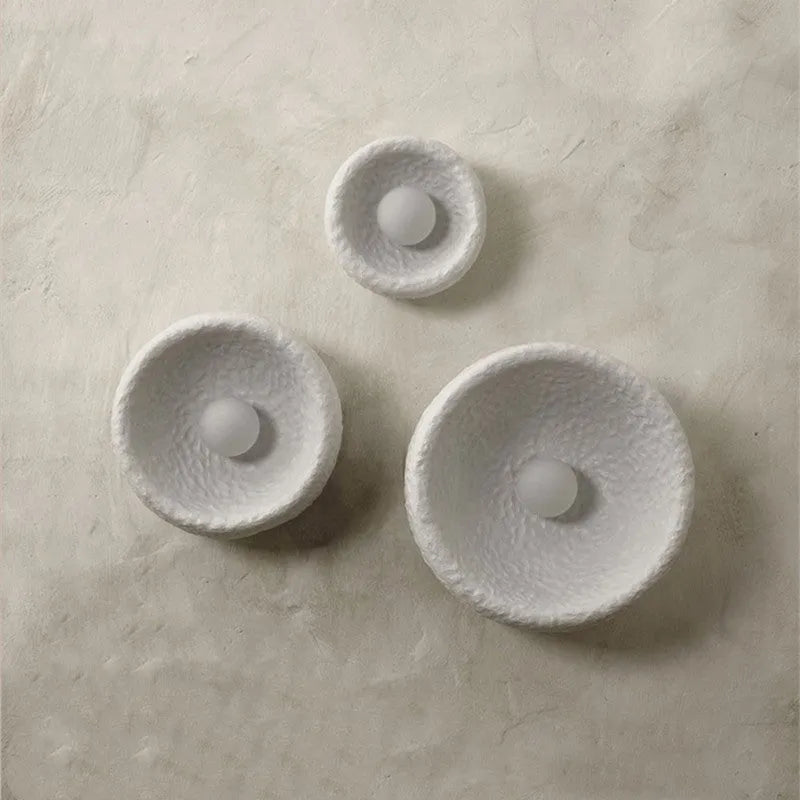 Japanese-style simple silent wall lamp with white resin shade in a modern room setting.