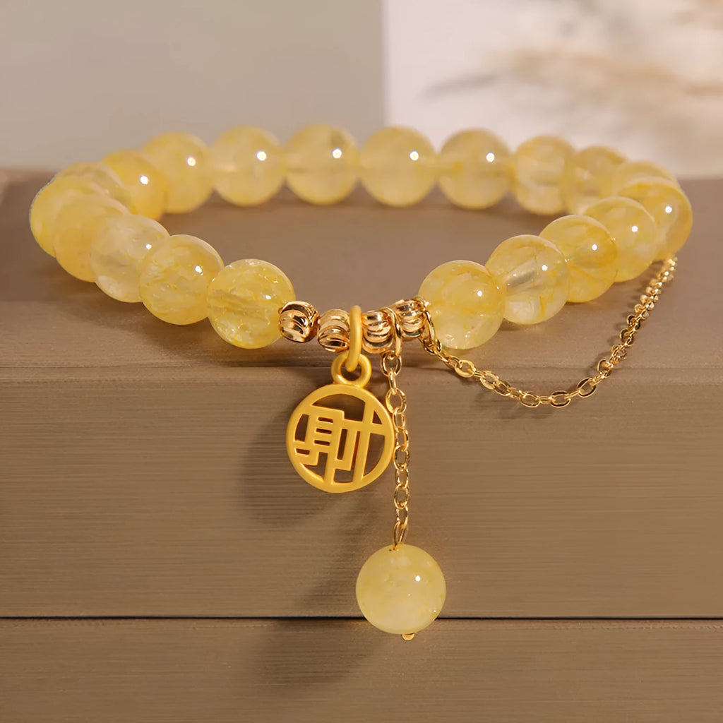Close-up of a women's natural citrine bracelet with an electroplated Chinese character tassel.