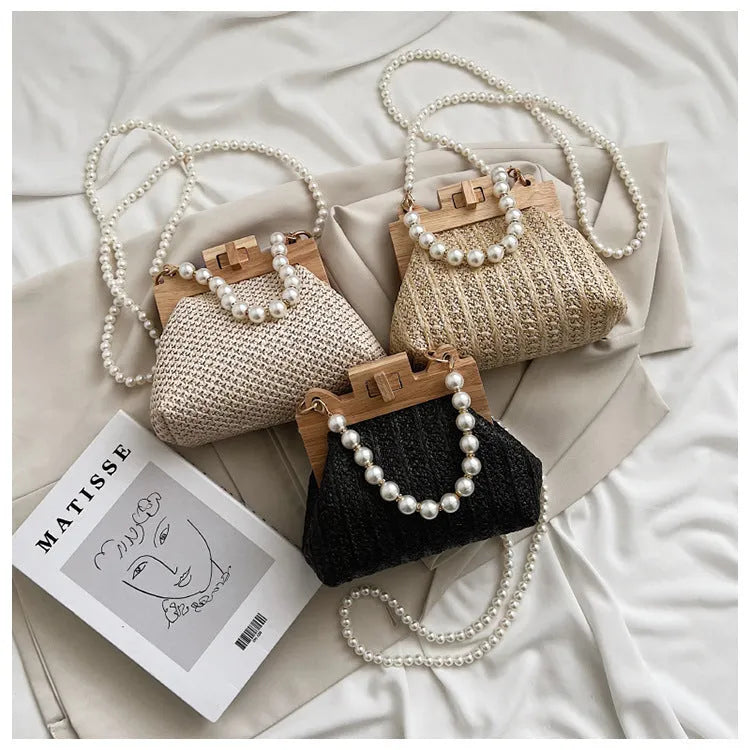 Women's horizontal square straw shoulder bag with pearl chain strap, shown in beige colour with visible sewing line detail.