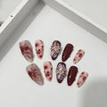 Hand-painted three-dimensional carved almond artificial nail extensions showing rose and tulip patterns