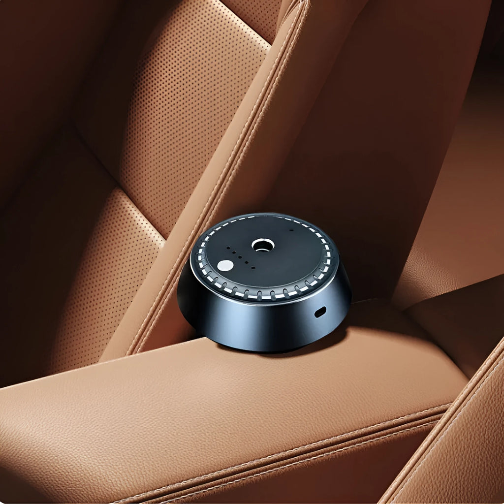 Black metal USB rechargeable car aroma diffuser with 30ml tank on a car dashboard.