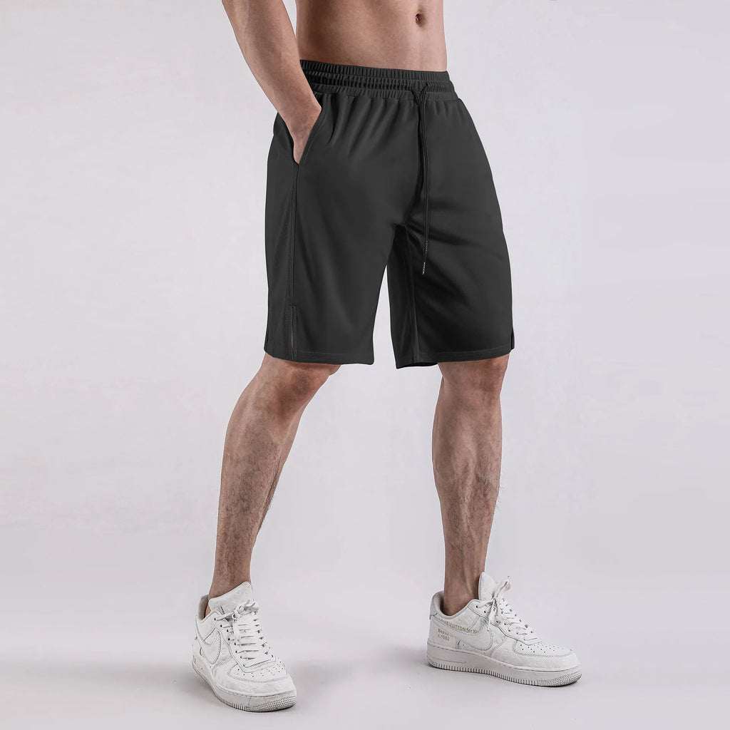 Man wearing loose black capri-length fitness shorts with an elasticated waistband.