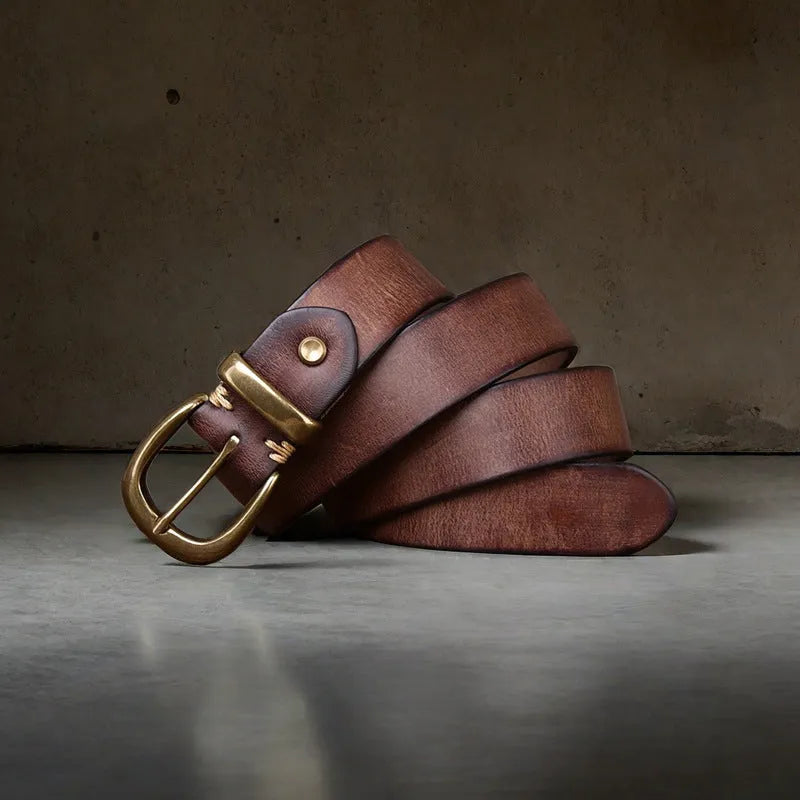 Men's black casual leather belt with a copper pin buckle on a jeans background.