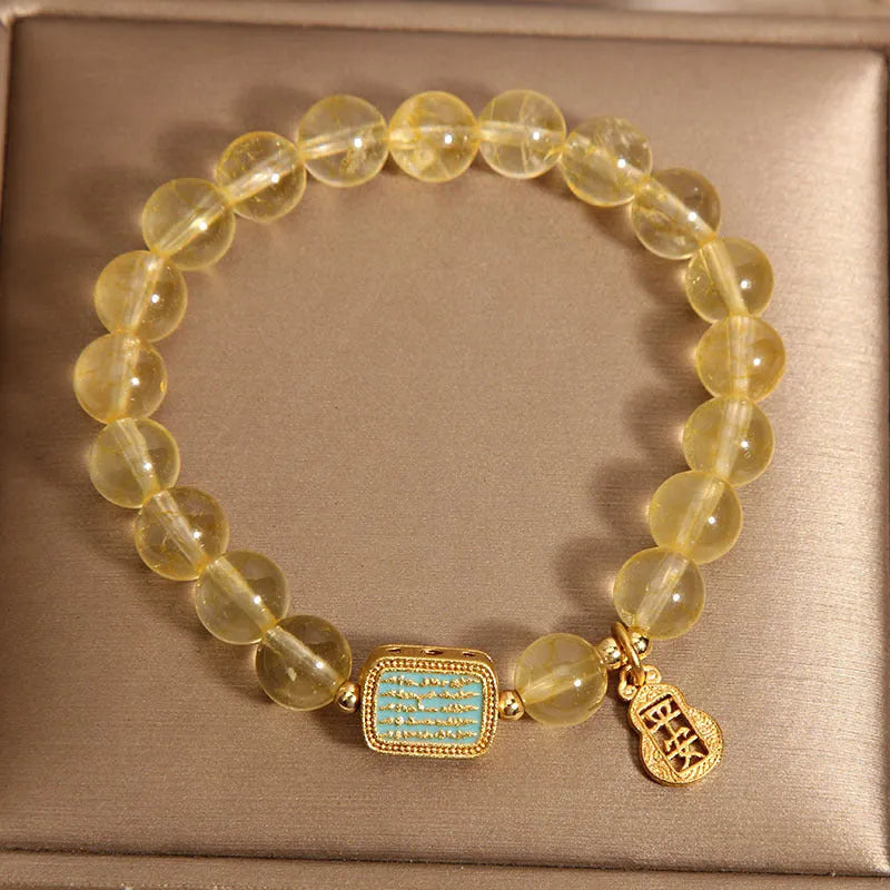 Women's yellow citrine crystal bracelet with sparkling rhinestone details on wrist.
