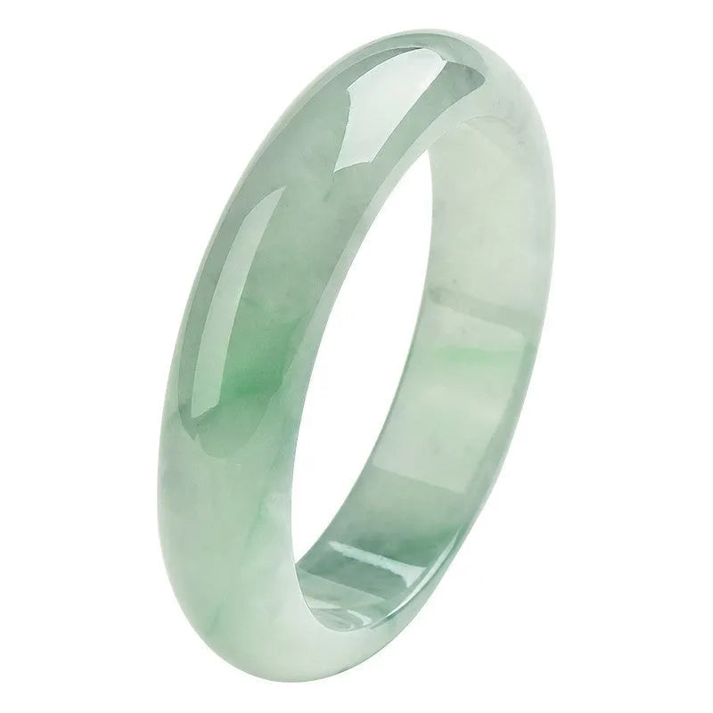Natural light green jade bracelet with a metal clasp, shown on a wrist.