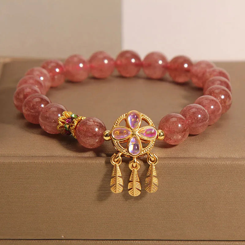 Women's strawberry quartz crystal bracelet with a four leaf dream catcher ball pendant.