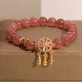 Women's strawberry quartz crystal bracelet with a four leaf dream catcher ball pendant.