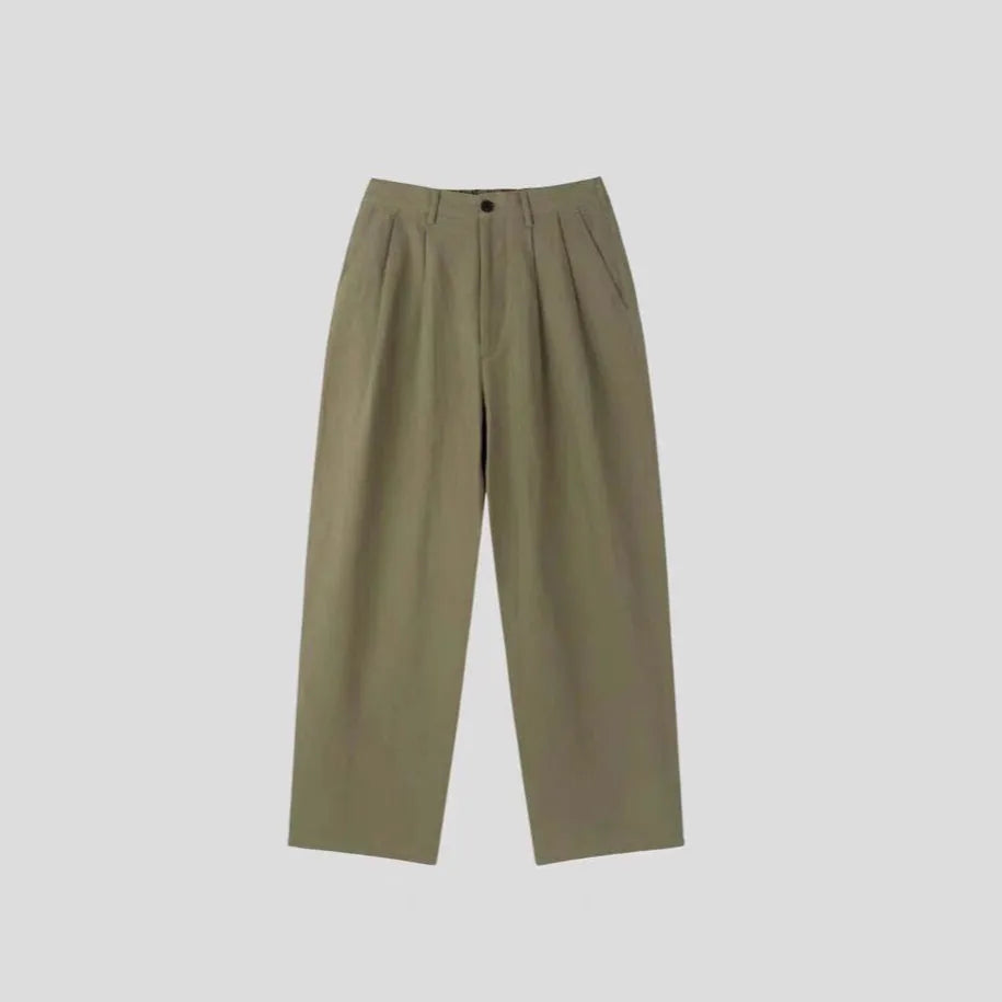 Men's light-weight wide-leg cotton linen trousers in apricot colour, showing loose fit and zip placket.