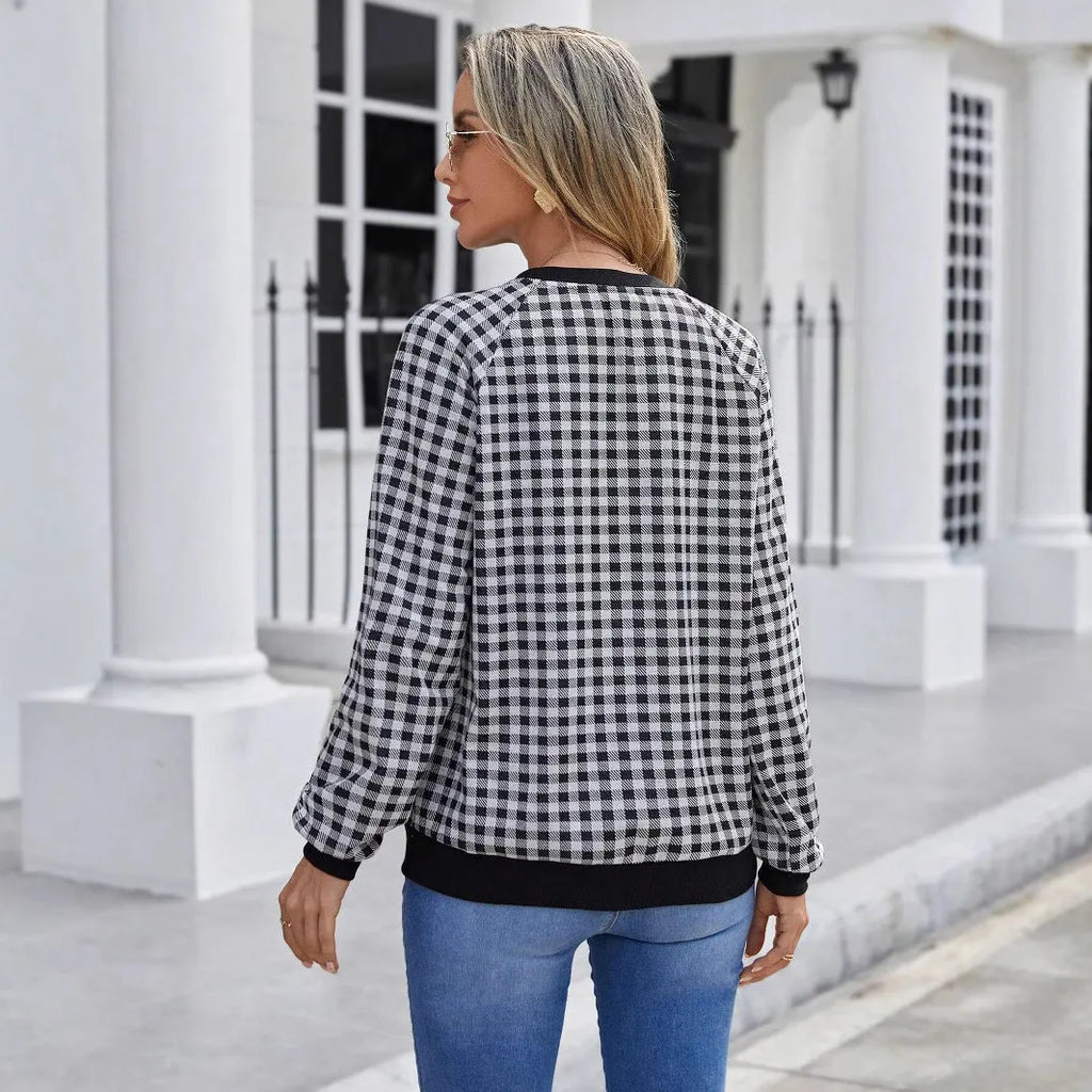 Black long sleeve pullover sweater with plaid stripes and printed pattern on a mannequin.