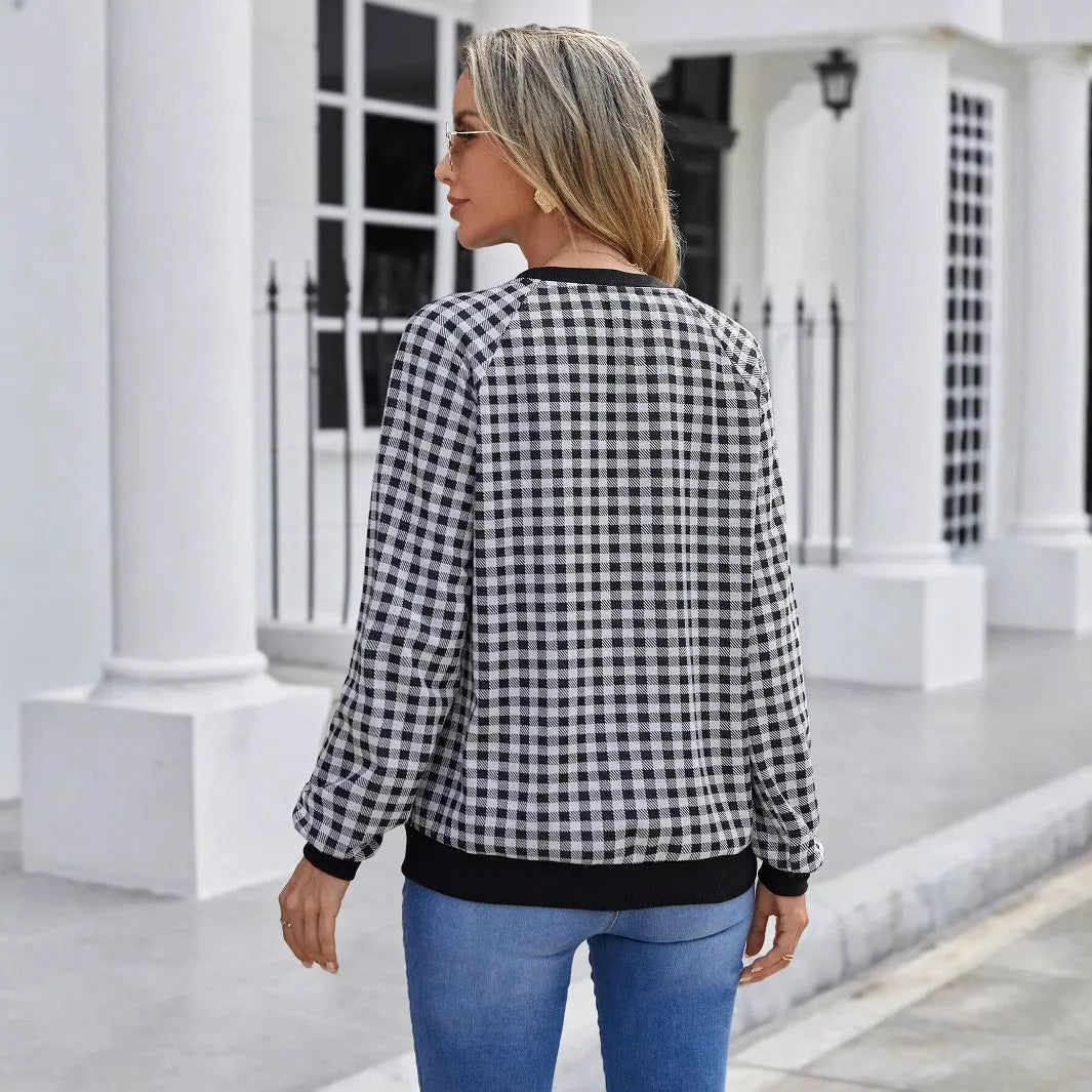 Black long sleeve pullover sweater with plaid stripes and printed pattern on a mannequin.