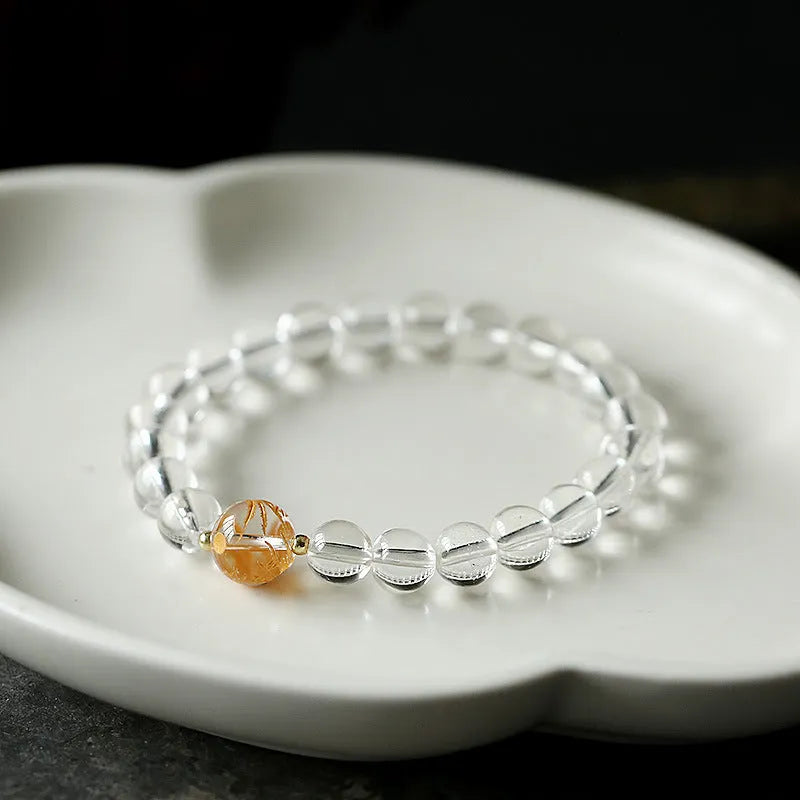 Geometric obsidian and white crystal bracelet with black agate beads and golden dragon charm on wrist