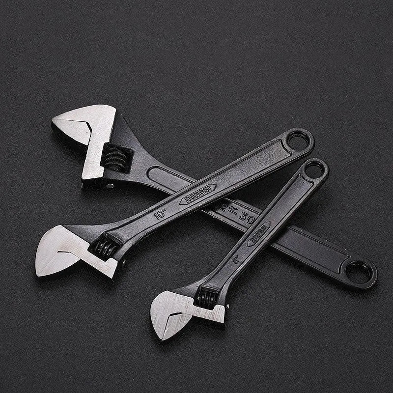 10-inch black high carbon steel adjustable open-end wrench on a workbench.