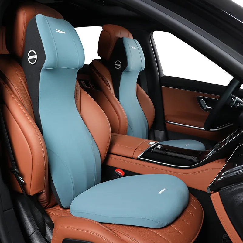Black memory foam automotive lumbar support cushion with integrated headrest on a car seat.